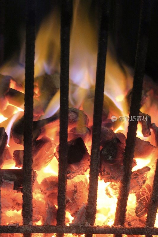 篝火的图像火与火坑火焰在生锈的金属火篮子燃烧木材/柴火，灼热的红色煤炭在室外壁炉/烧烤木炭烧烤加热照片，保持温暖在晚上在花园露营地点的篝火